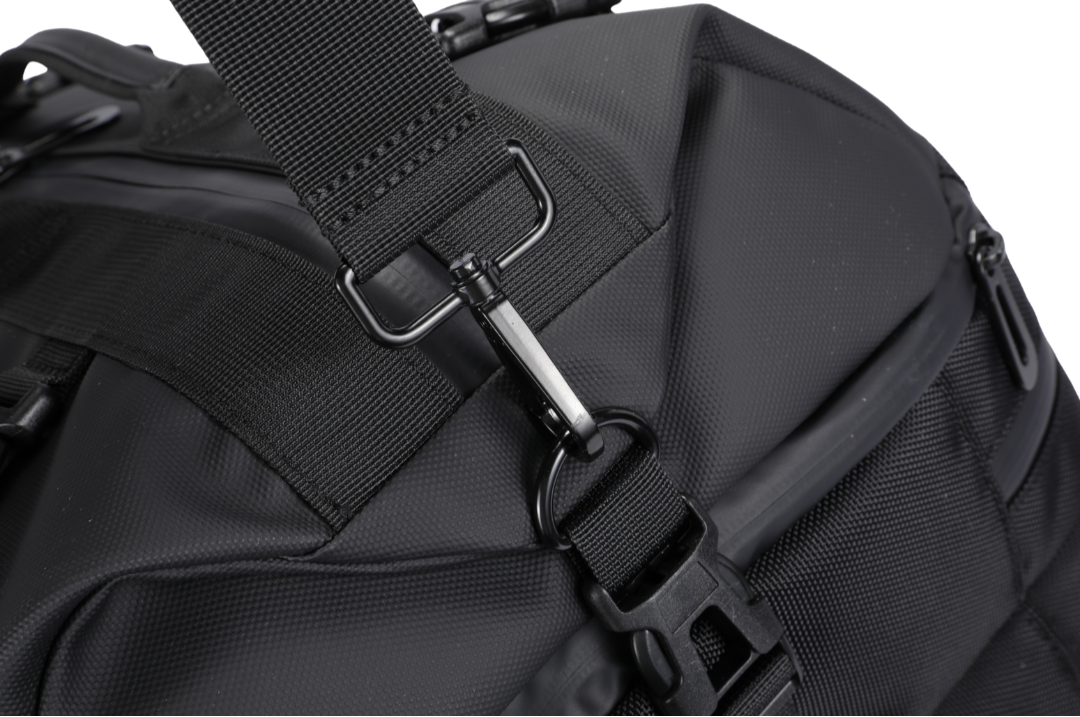 Close-up of a black backpack with a strap and buckle on a white background