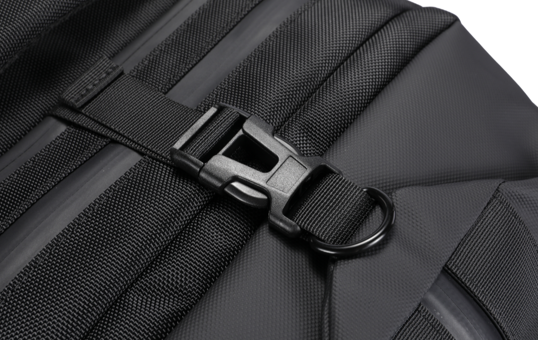 Close-up of a black suitcase with a strap and buckle on a white background