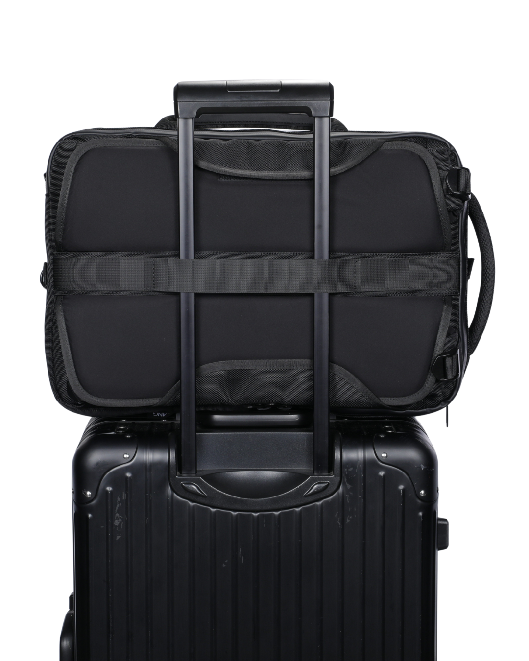 Black suitcase with a black backpack on top, featuring a shoulder strap.