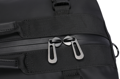 Close-up of a black bag with zippers and straps on a white background